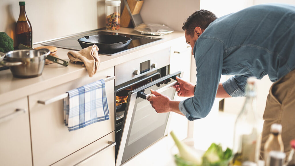 Man cooking with an electric oven and stove top