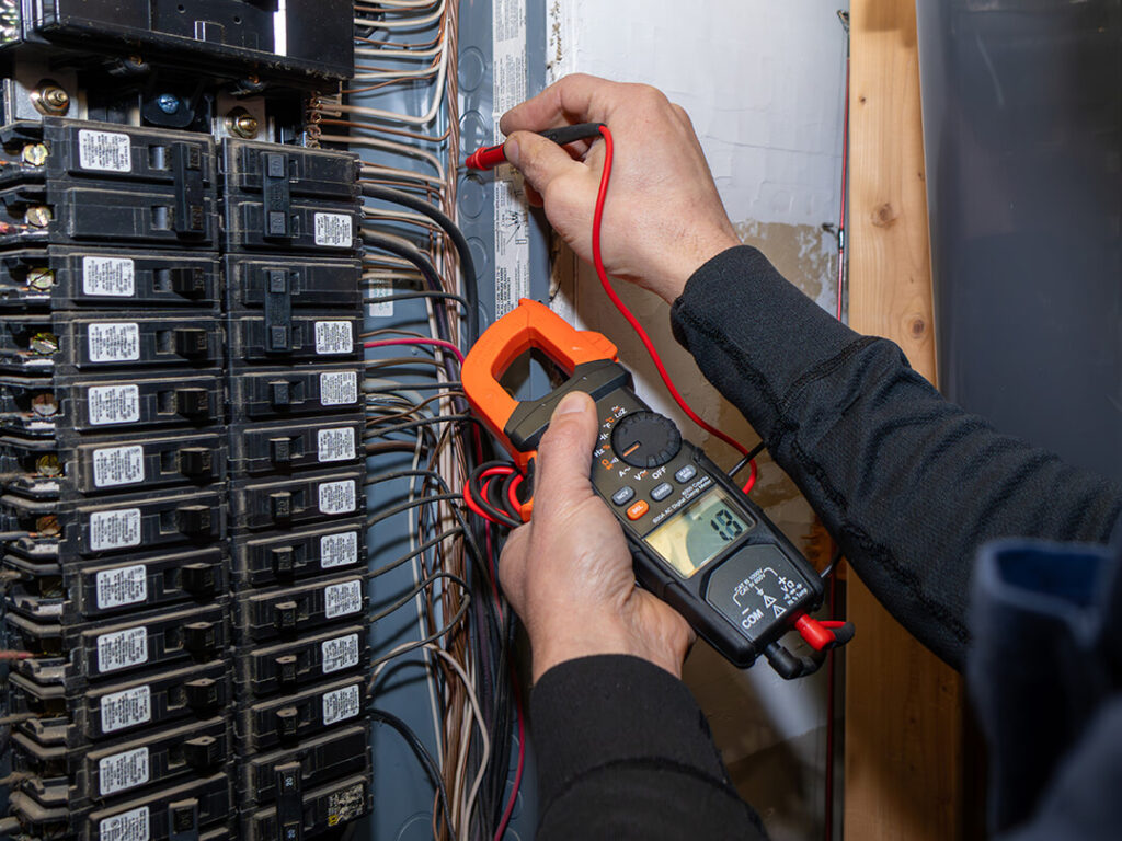 Technician using a meter on an electrical panel