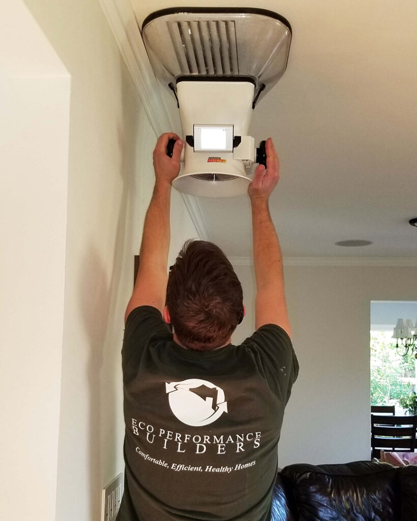 A technician measures airflow from a heating and cooling system